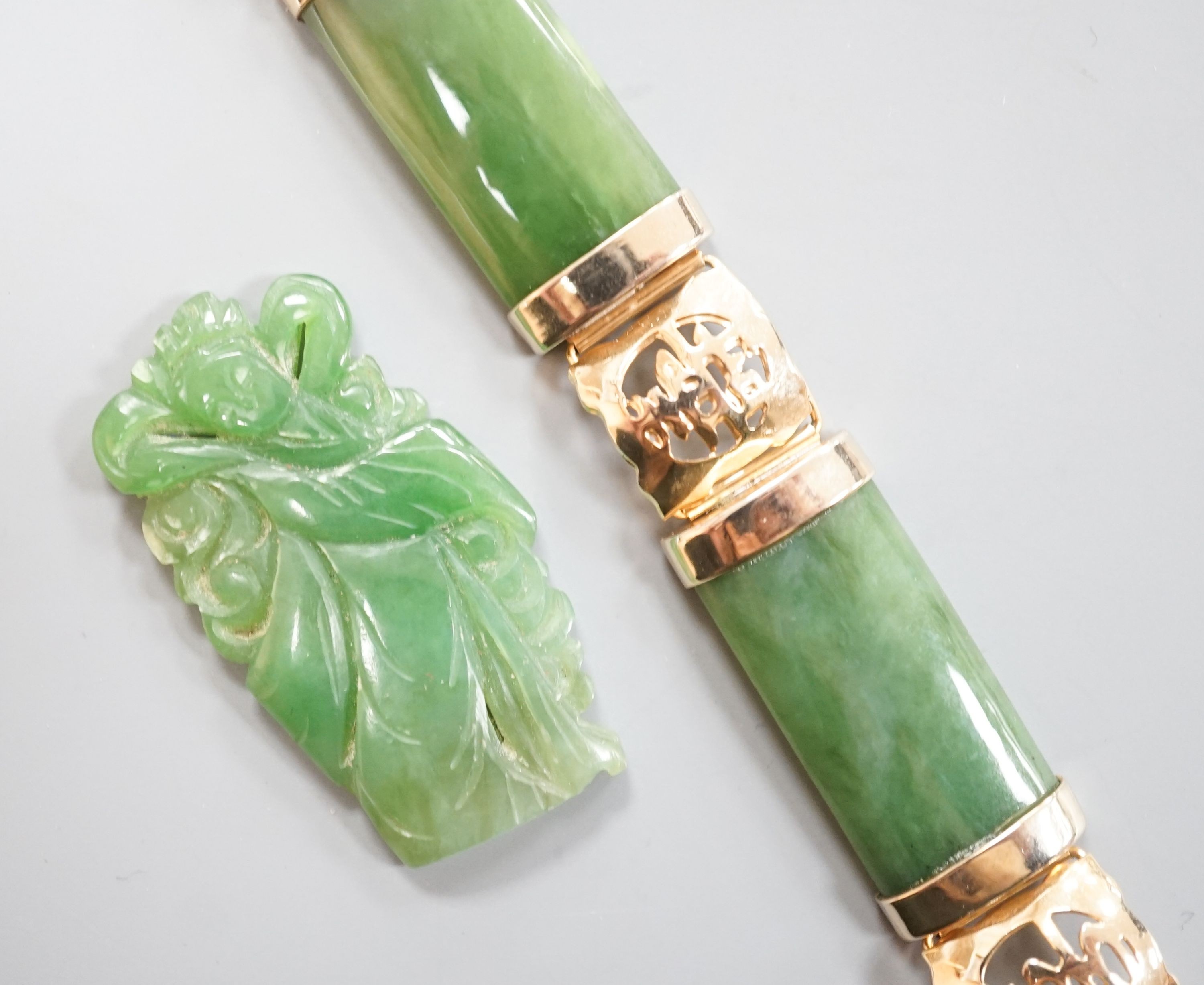 A gilt metal and jadeite mounted bracelet, 17.4cm and a carved plaque.